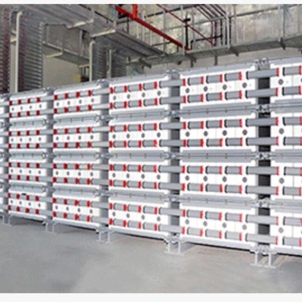 Stacks of modular white and red industrial panels stored in a warehouse.