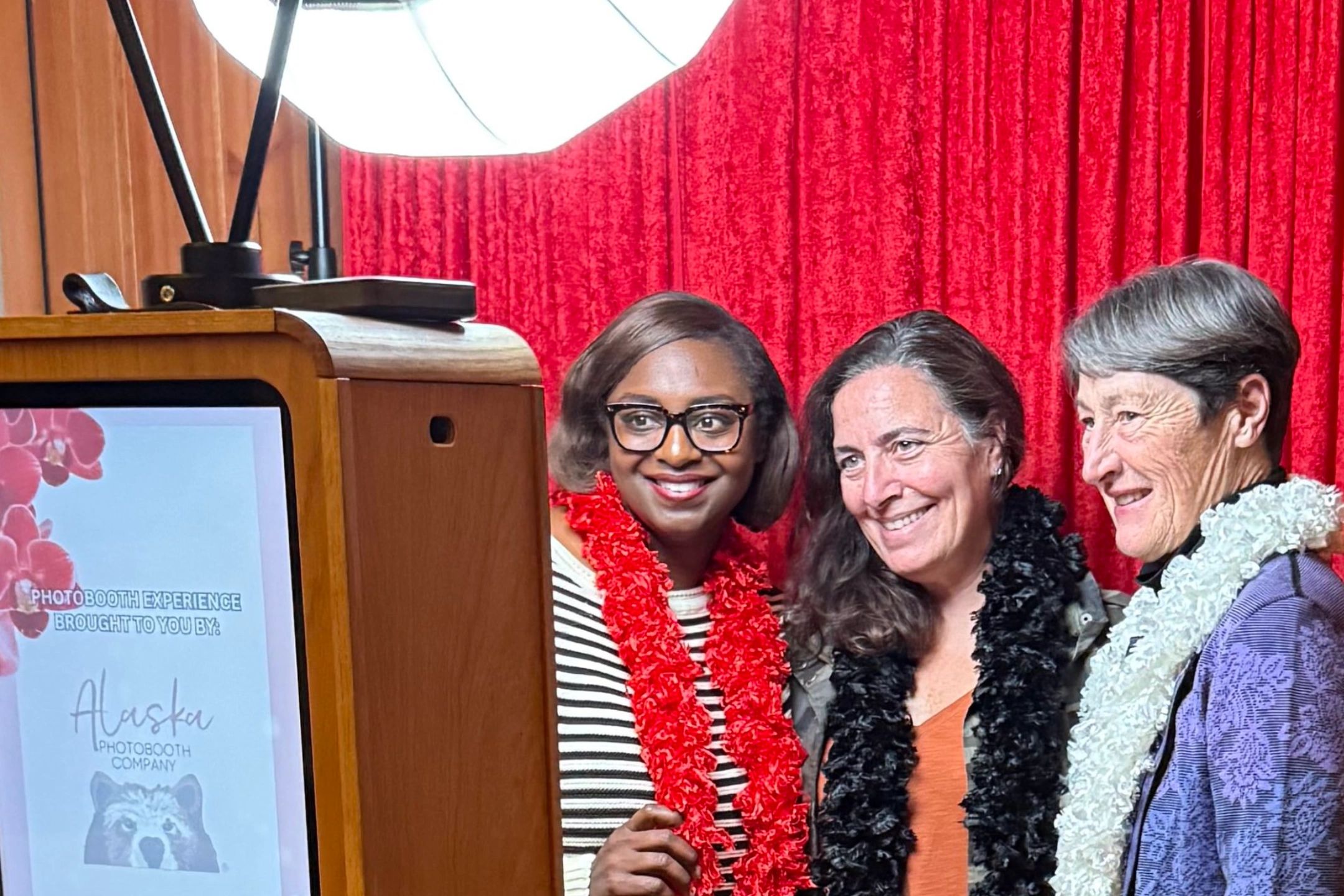 Women posing with props in Alaska photo booth rental at Go Red for Women event