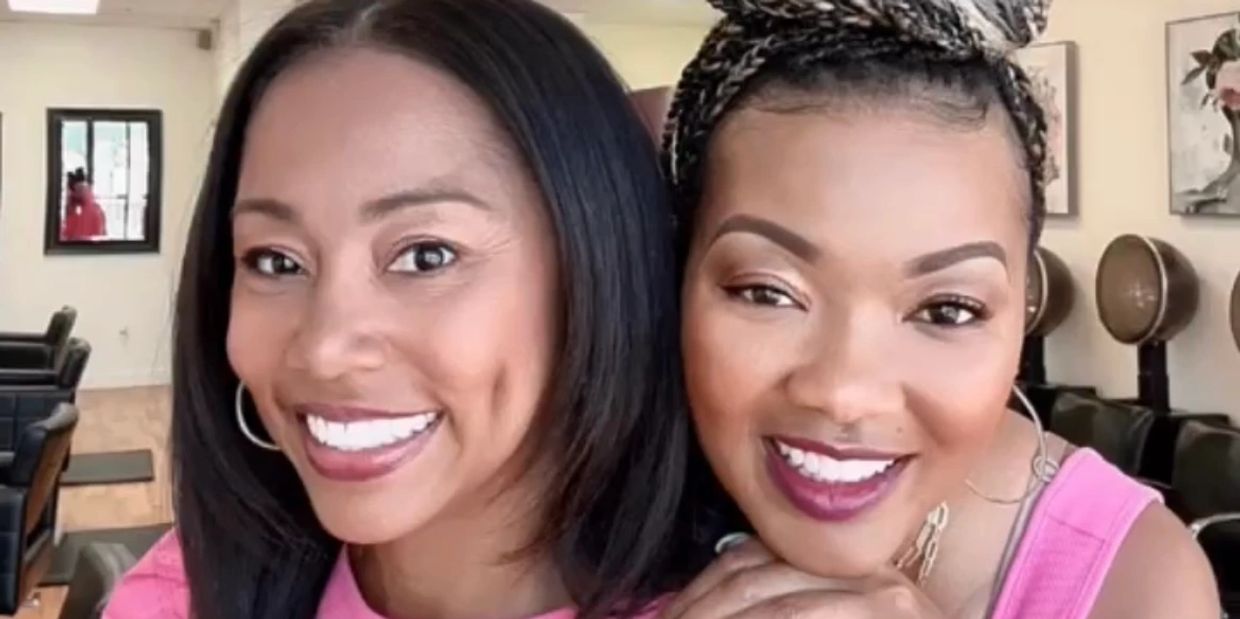 Two women smiling closely together indoors.