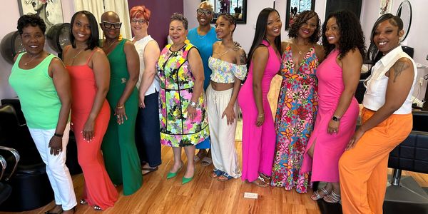 Group of women dressed in colorful outfits posing indoors.