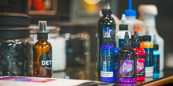 Colorful tattoo ink bottles on a table.
