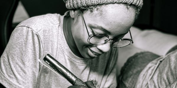 Person writing with a marker and smiling.