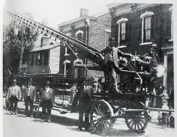 Vintage firefighter crew with early fire truck.