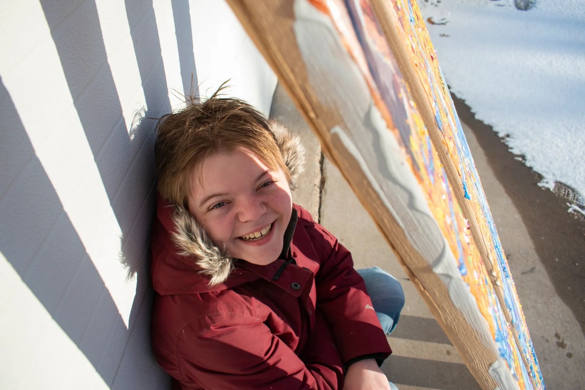Self-portrait of artist Rachel Albee taken outside behind wooden bars.