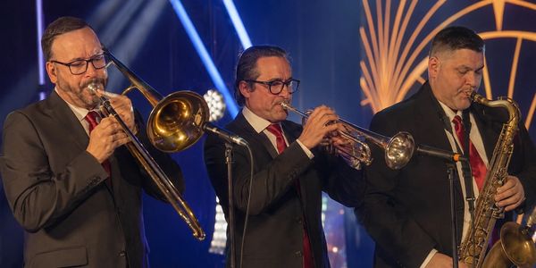 The High Rollers horn section delivering a high-energy live performance in Las Vegas with saxophone, trumpet, and trombone.