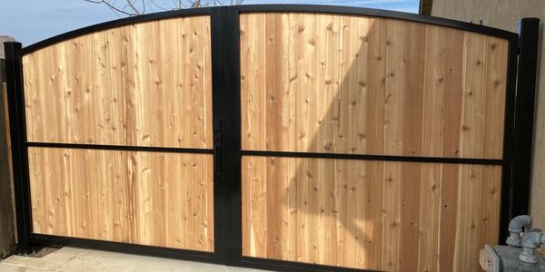 Modern wood panel & black steel double swing gate with clean horizontal lines, for residential use.