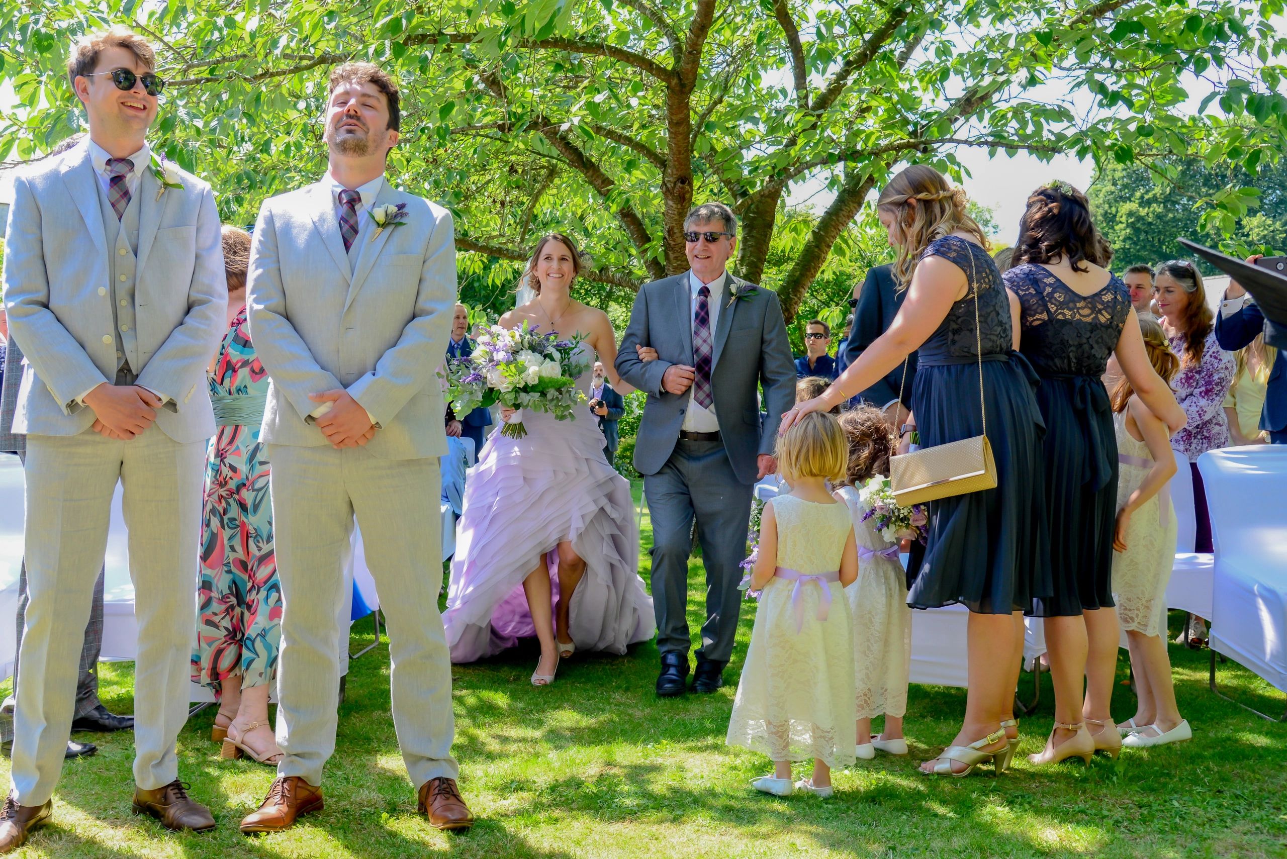 Barn wedding Dorset. father walking bride down aisle nervous groom emotional photograph Laura Miller