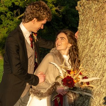 Golden hour photograph autumnal photo of bride and groom by oak tree rural farm wedding Wales