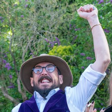 Candid wedding photograph wedding guest cheering with arm in air wedding photographed in Wales