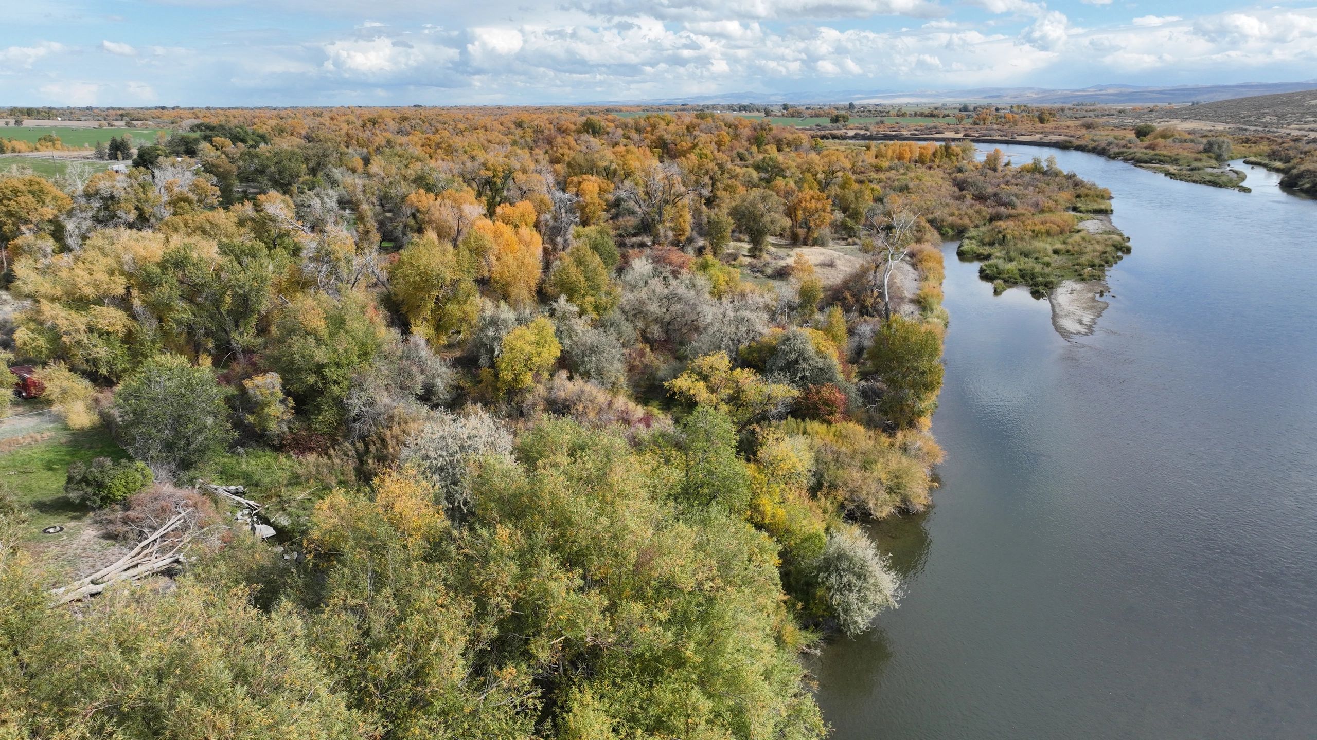 Aerial view of the Snake River bordered by trees in autumn colors.