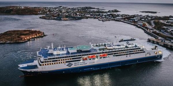 A large Marine Atlantic ferry docked near a coastal town.