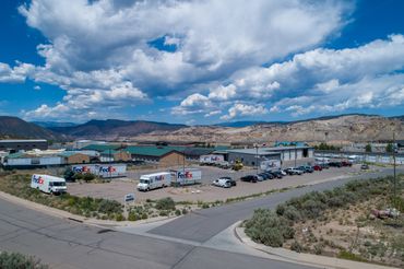 A drone photo of a small FedEx distribution center in the foreground with mountains in the backgroun