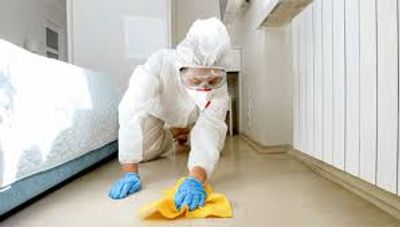 Technician in a protective suit cleaning a floor by hand, unattended death cleanup in San Jose