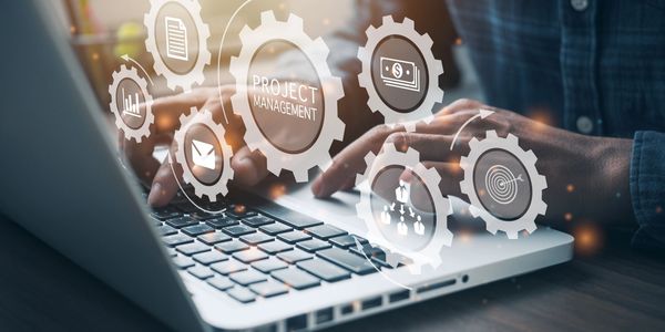 Hands typing on a laptop with project management icons overlayed.