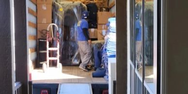 Two men loading or unloading furniture inside a moving truck.