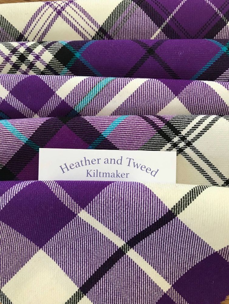 Kilt material in purple shades with a business card in between