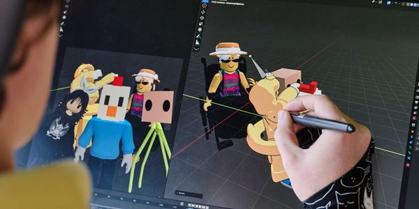 Person creating Roblox avatars using 3D modeling software on a computer.