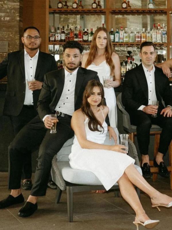 Wedding party posing in custom tailored dresses and suits