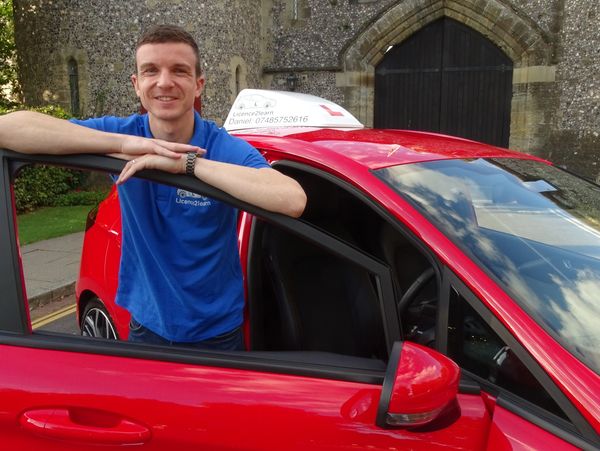 man standing and smiling by car