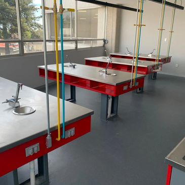 Mesa escolar con papeleras de 1.00X2.40X0.90 mts. cubierta en a. inox y servicio de gas y agua 