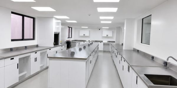 Laboratorio blanco moderno y limpio con encimeras metálicas.