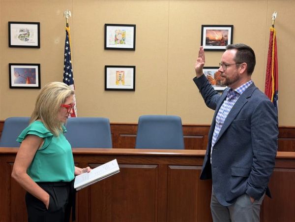 Man taking an oath with woman reading from a book.