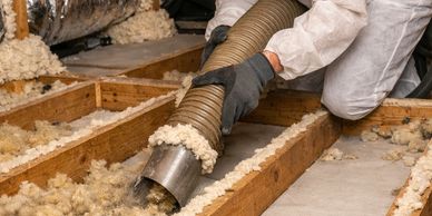 Worker installing insulation in an attic.