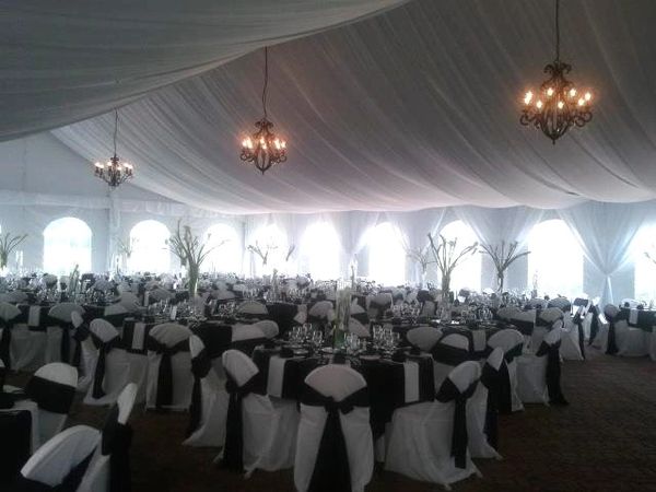Elegant banquet hall with black and white decor and chandeliers.