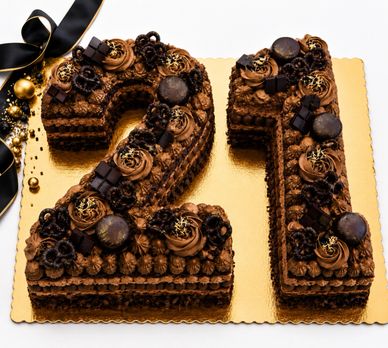 Chocolate number 21 cake decorated with chocolates and gold accents.