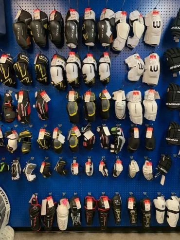A wall display of various hockey gloves in different colors and brands.