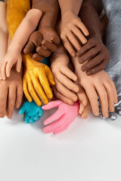 Diverse colorful artificial hands in various skin tones and materials arranged together.
