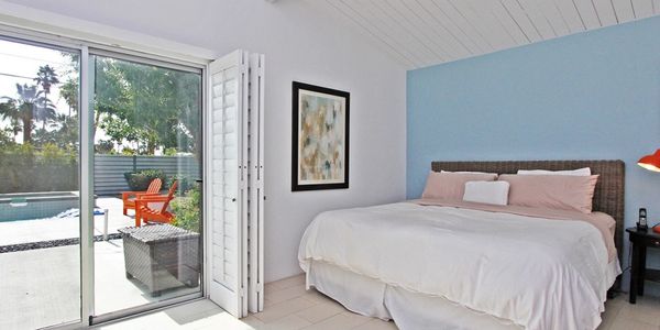Midcentury floor to ceiling glass design in the primary bedroom.