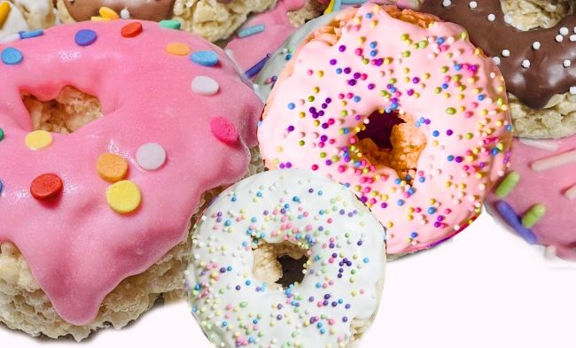 Colorful frosted donuts with sprinkles in various flavors.