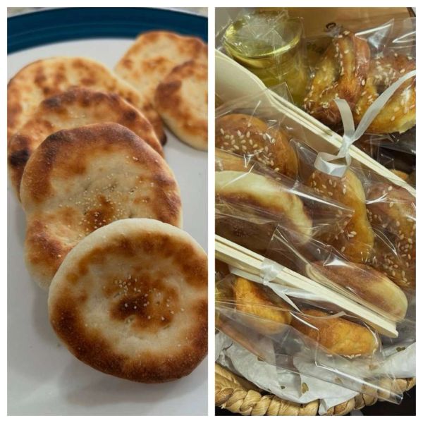 Close-up of baked sesame-topped bread on a plate and wrapped packs.