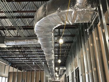 Custom hung ductwork from the ceiling, designed to manufacturer specs for optimal HVAC efficiency.