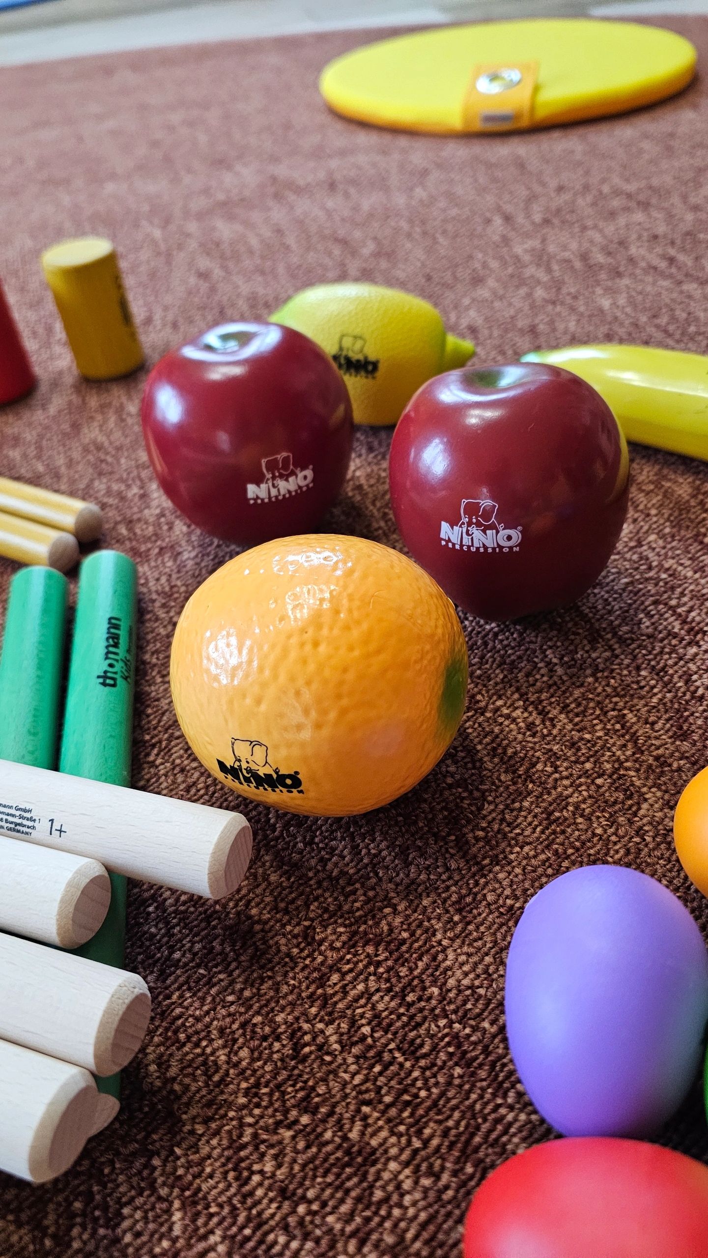 Bunte Holzspielzeuge und Musikinstrumente auf Teppich.