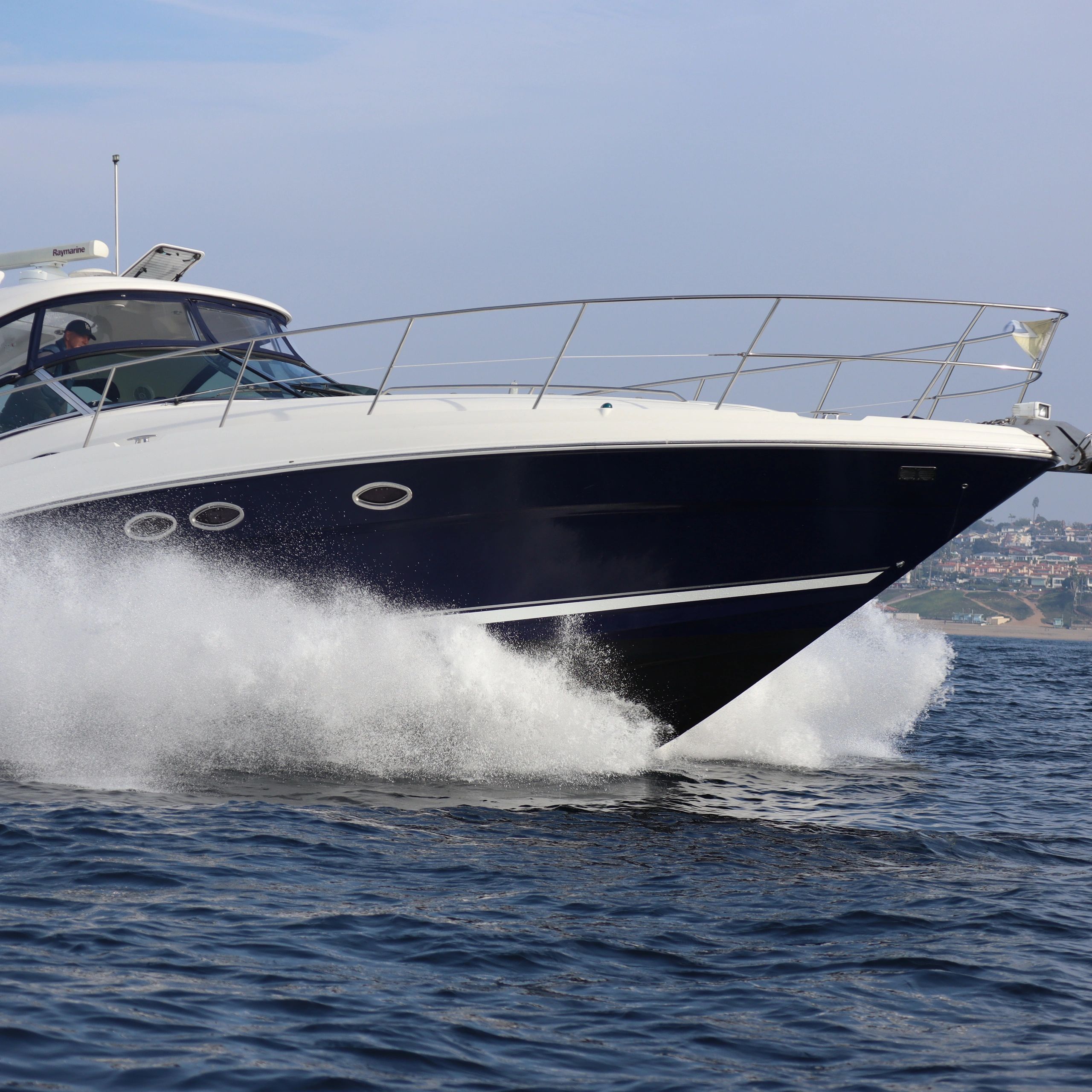 A sleek yacht cutting through the ocean water at high speed.
