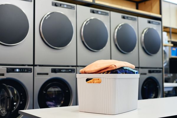 The image depicts a modern laundromat or a commercial laundry facility.