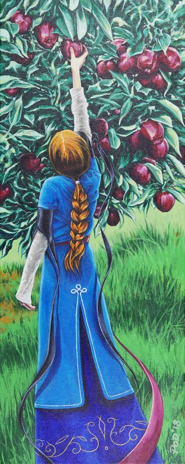 Young woman viewed from behind, picking an apple from an apple tree