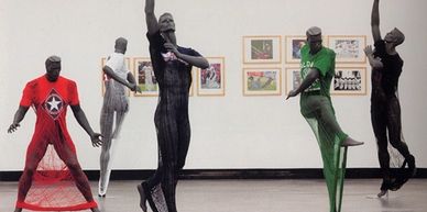 Sculptures of dancers in colorful, sheer fabrics posed in a gallery space.