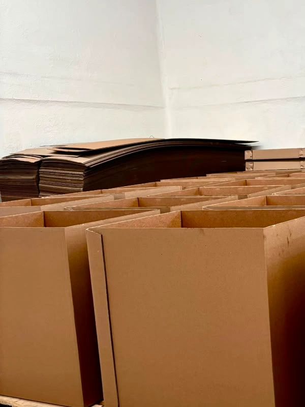Stacks of empty cardboard boxes arranged in rows inside a room.