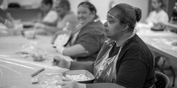 Workers focused on food preparation in a communal kitchen.