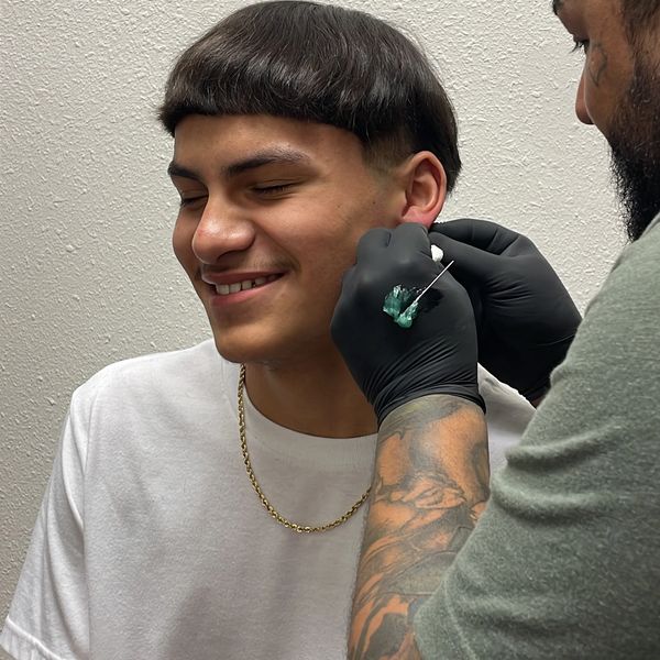 a piercer piercing a lobe