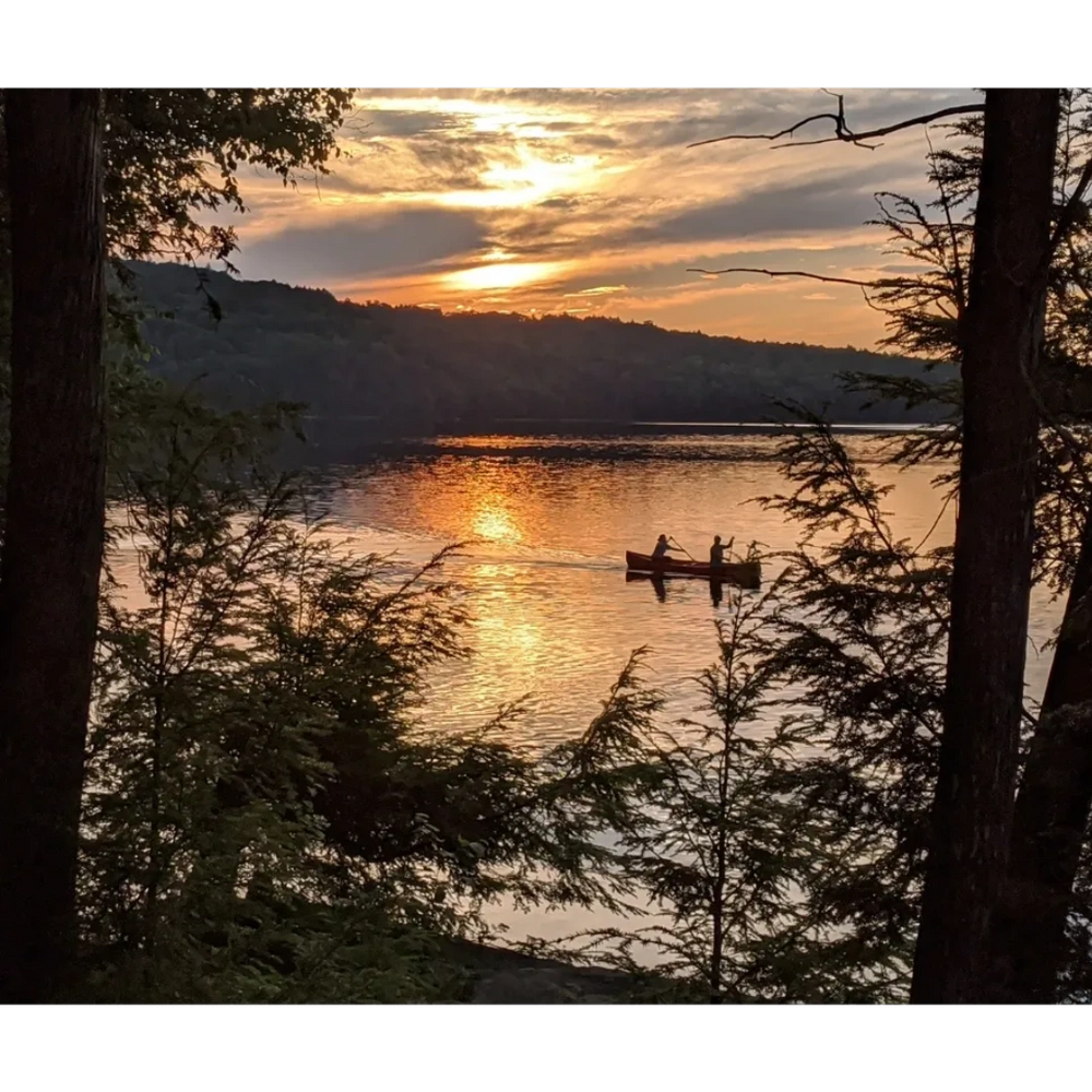 Two people canoeing at sunset