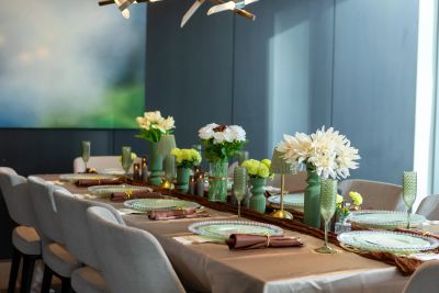 Elegant dining table set with flowers and glassware in a modern room.