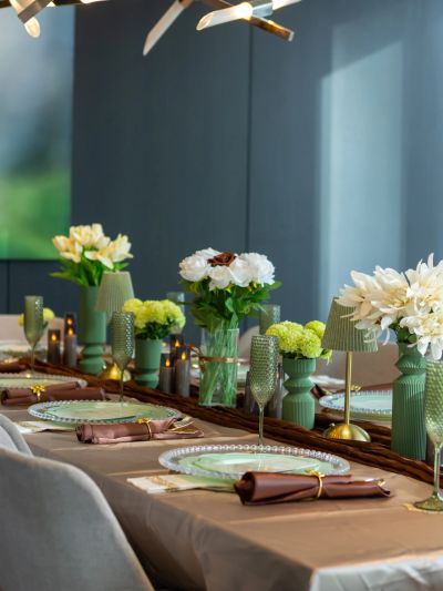 Elegant dining table set with flowers and glassware in a modern room.