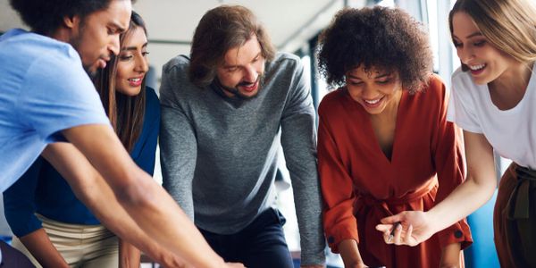 A group of diverse colleagues happily collaborating on a project.