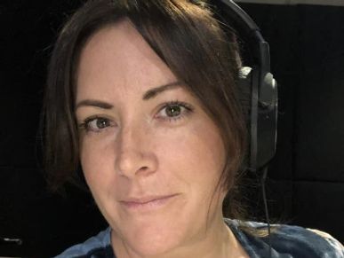 Woman wearing headphones in a recording studio.