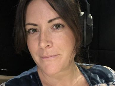 Woman wearing headphones in a recording studio.