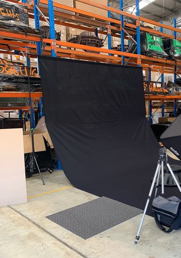 Setting up mobile studio with black back drop for product photography